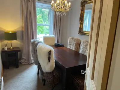 a dining room table with chairs and a mirror at River View in Dumfries
