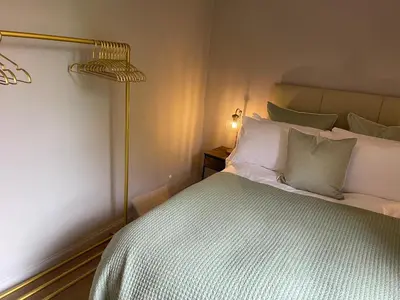a bedroom with a bed with a white bedspread and a lamp at River View in Dumfries