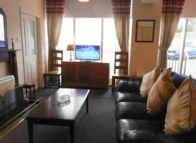 a living room with a couch and a tv at THE COACH HOUSE in Moffat