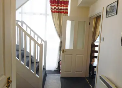a hallway with a white door and stairs at THE COACH HOUSE in Moffat