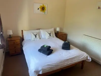 a bedroom with a bed with two towels on it at Rowan Cottage Wanlockhead Dumfries & Galloway in Wanlockhead