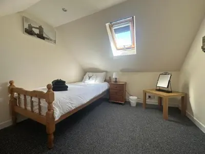 a bedroom with a bed and a table and a window at Rowan Cottage Wanlockhead Dumfries & Galloway in Wanlockhead