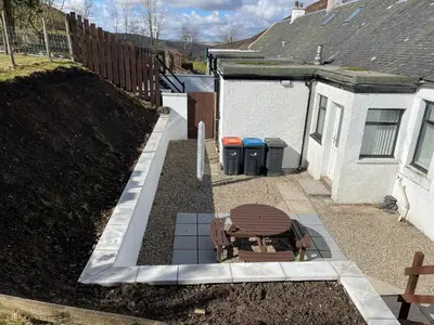 a patio with a bench and two trash cans at Rowan Cottage Wanlockhead Dumfries & Galloway in Wanlockhead