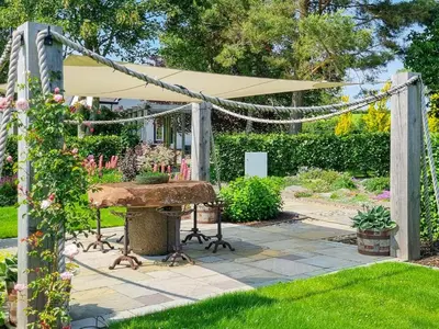 a picnic table in a garden with a canopy at Beacon Cottage in Ivegill