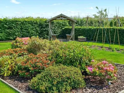 a garden with a swing and some flowers at Beacon Cottage in Ivegill