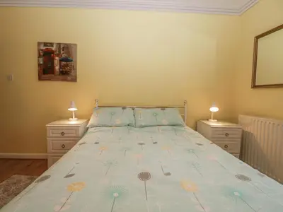 a bedroom with a bed and two night stands at Beckside Farm in Millom