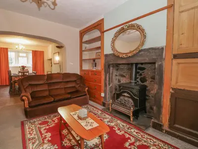 a living room with a couch and a fireplace at Beckside Farm in Millom