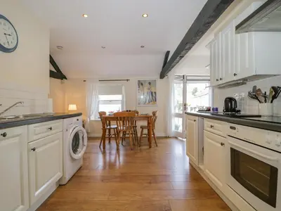 a kitchen with white cabinets and a table with chairs at The Old Mill in Keswick