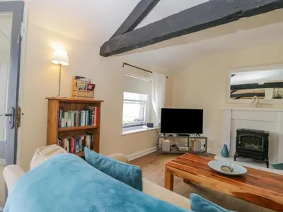 a living room with a couch and a tv at The Old Mill in Keswick
