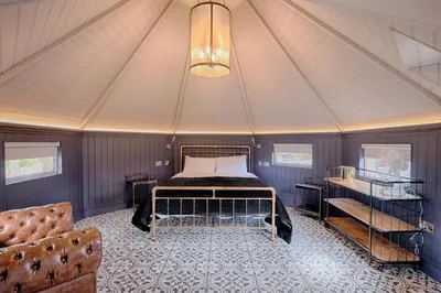 a bedroom in a tent with a bed and a couch at Enterkine Country House Resort in Annbank
