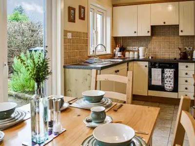 a kitchen with a wooden table with plates and bowls on it at Sinclair's in Gatehouse of Fleet
