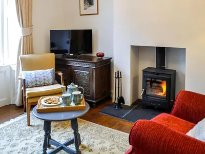 a living room with a fireplace and a stove at Sinclair's in Gatehouse of Fleet