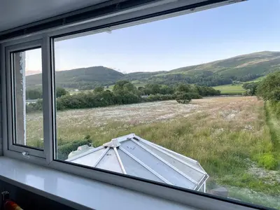 a window with a view of a field with an umbrella at Fell View in Lorton