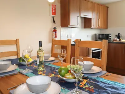 a dining room table with plates and glasses of wine at Tilly Mint Cottage in Penrith