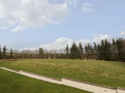a large grassy field with trees in the background at Tilly Mint Cottage in Penrith
