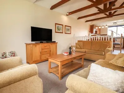 a living room with a flat screen tv and furniture at Tilly Mint Cottage in Penrith