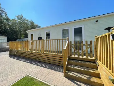 a wooden deck with a fence in front of a house at Discover, Enjoy Ultra-Fast Starlink WiFi Lodge in Carlisle
