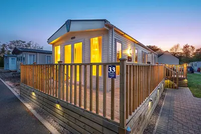 a tiny house with yellow lights on a fence at Discover, Enjoy Ultra-Fast Starlink WiFi Lodge in Carlisle