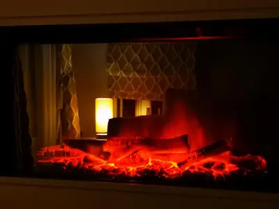 a fire in a fireplace with a lamp in it at Discover, Enjoy Ultra-Fast Starlink WiFi Lodge in Carlisle
