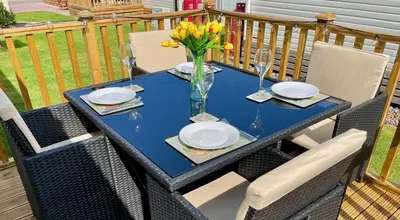 a blue table with plates and a vase of flowers at Discover, Enjoy Ultra-Fast Starlink WiFi Lodge in Carlisle