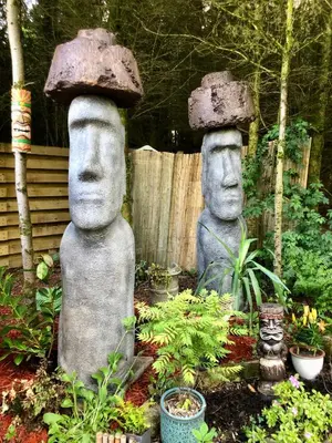 two statues with hats on their heads in a garden at Ayrshire Airstream in Galston