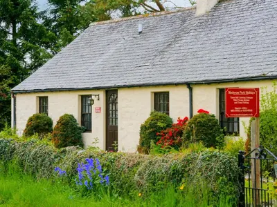 a white house with a sign in front of it at The Smithy - Uk38001 in Kirkcowan