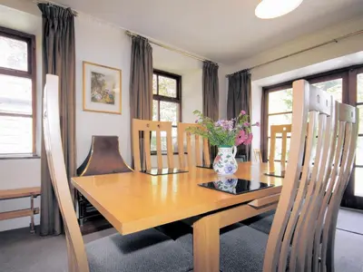 a dining room table with a vase of flowers on it at The Coach House - Uk38000 in Kirkcowan