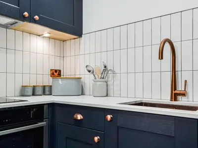a kitchen with blue cabinets and a sink at The Old Stable in Keswick