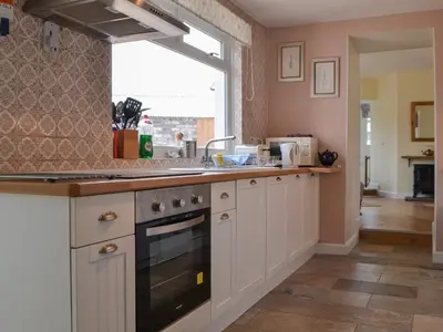 a kitchen with a sink and a stove at Old Saddlers Cottage in Ireby