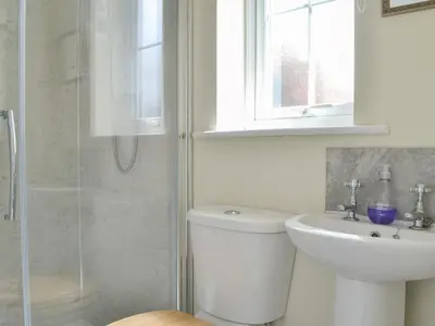 a bathroom with a toilet and a sink and a shower at Old Saddlers Cottage in Ireby