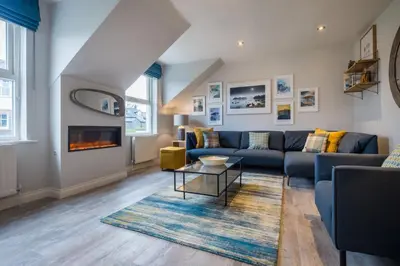 a living room with a blue couch and a fireplace at Howe Keld 6 Second Floor in Keswick