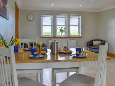 a dining room with a table with food on it at Knockinaam House in Colfin