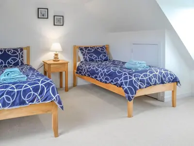 a bedroom with two beds with blue comforter at Knockinaam House in Colfin