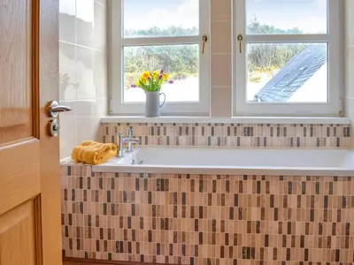 a bathroom with a sink and two windows at Knockinaam House in Colfin