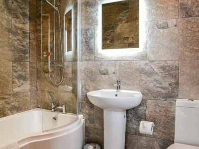 a bathroom with a sink and a toilet and a bath tub at Chestnuts in Burgh by Sands