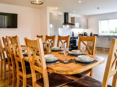 a kitchen and dining room with a wooden table and chairs at Chestnuts in Burgh by Sands