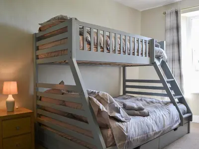 a bunk bed with a ladder in a room at Fieldside Farmhouse in Tallentire