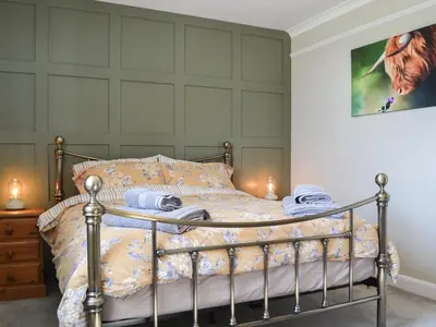 a bedroom with a metal bed with a wall at Fieldside Farmhouse in Tallentire