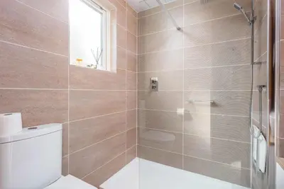 a bathroom with a toilet and a shower at London Gate No1 - Donnini Apartments in Kilmarnock