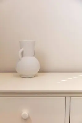 a white vase sitting on top of a cabinet at London Gate No1 - Donnini Apartments in Kilmarnock