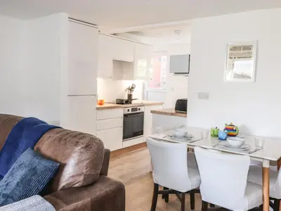 a living room with a couch and a table with chairs at Sparrow Cottage in Keswick