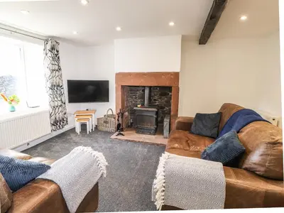 a living room with a couch and a fireplace at Sparrow Cottage in Keswick