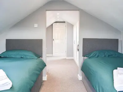 a bedroom with two beds and a mirror at Rosedean in Ireby