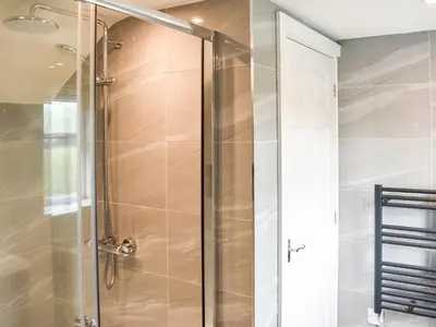 a shower with a glass door in a bathroom at Rosedean in Ireby