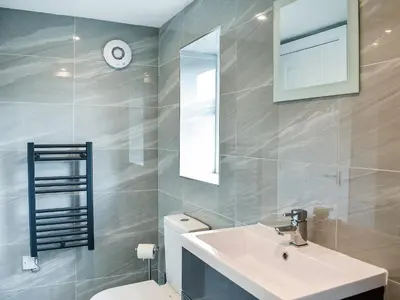a bathroom with a sink and a toilet and a mirror at Rosedean in Ireby