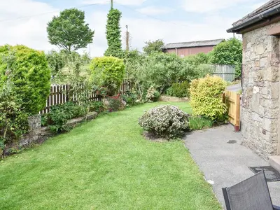 a backyard with a yard with a fence and grass at Rosedean in Ireby