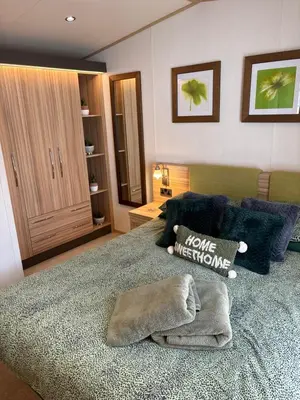 a bedroom with a large bed with a sign on it at Squirrel Lodge (Unit 7) in Carlisle