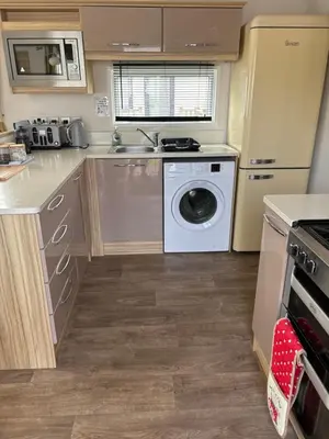 a kitchen with a washing machine and a washer at Squirrel Lodge (Unit 7) in Carlisle