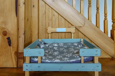 a blue bed in a room next to a staircase at The Steading at Castle Creavie Farm in Kirkcudbright