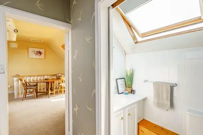 a bathroom with a skylight and a dining room at The Cheeseloft - Spacious one bed with terrace in Kirkcudbright